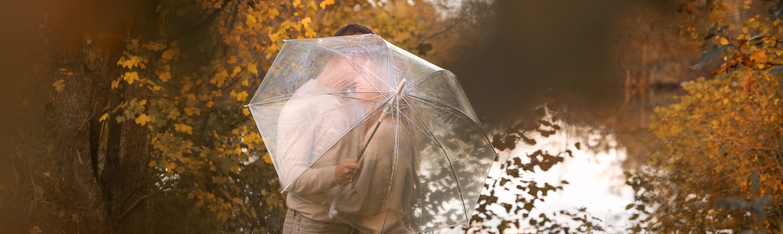 Pärchenfotografie Ingolstadt: Verliebtes Paar hinter Regenschirm im Herbstwald, Anton Gil.
