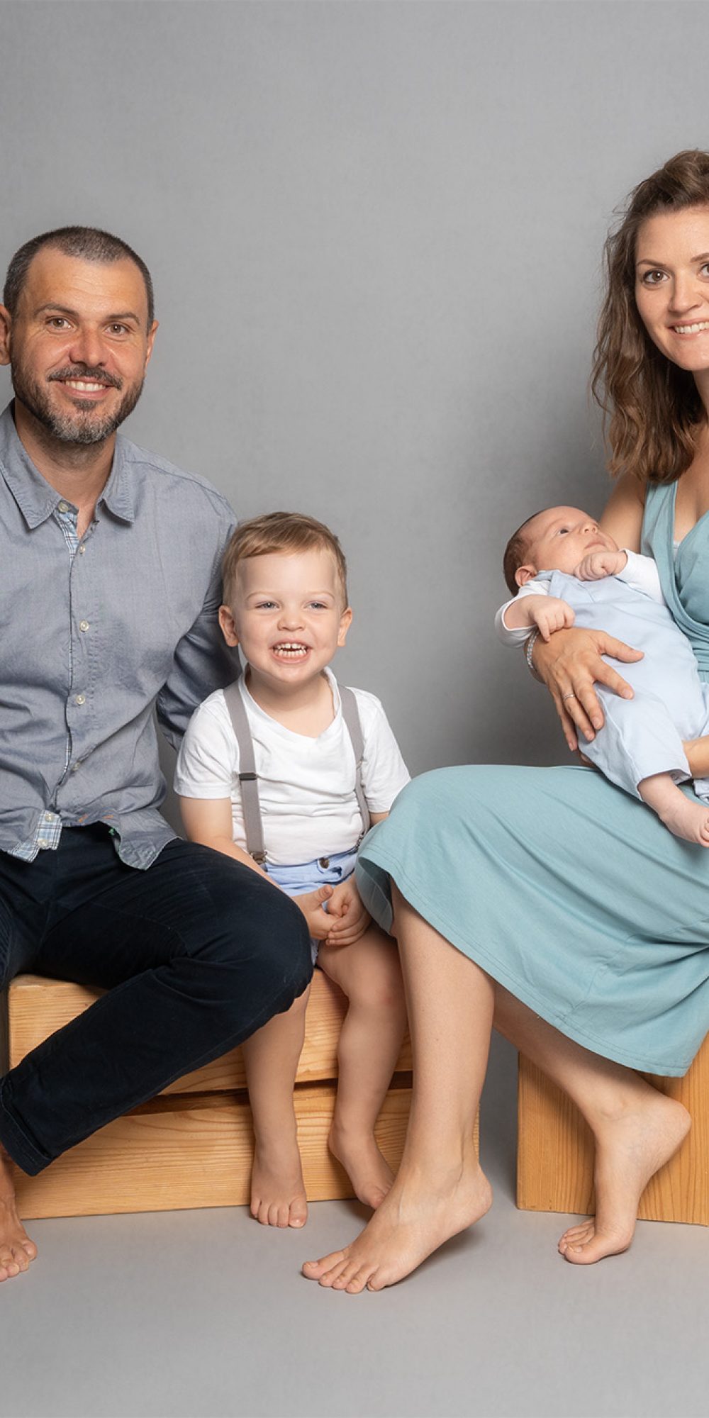 Familienfotografie Offenstetten: Vierköpfige Familie vor grauem Hintergrund, Studioblitz, Anton Gil Fotografie.